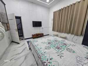 a bedroom with a bed and a tv in it at AnjuShyam HomeStay in Agra