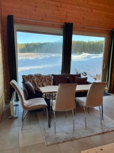una sala da pranzo con tavolo e sedie e una grande finestra di W lesie nad rzeką a Rolbik