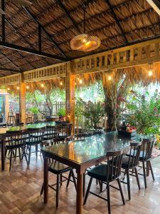 a dining room with tables and chairs and plants at Tam Coc Central Backpacker Hostel in Vũ Lâm
