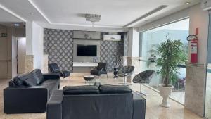a living room with a black couch and chairs at Hotel Paraiso in Correia Pinto