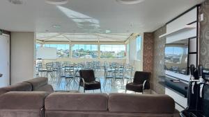 a room with a couch and a table and chairs at Hotel Paraiso in Correia Pinto