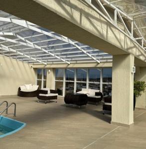 a patio with couches and a pool in a building at Hotel Paraiso in Correia Pinto