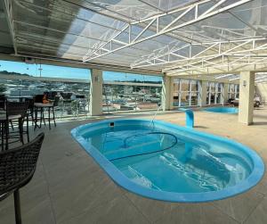 a large blue swimming pool in a building at Hotel Paraiso in Correia Pinto