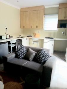 a living room with a couch and a kitchen at The Corner Nest in Roodepoort