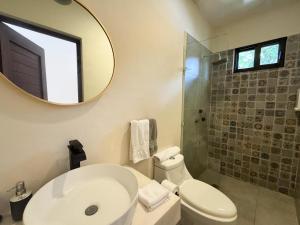 a bathroom with a toilet and a sink and a mirror at Esencia Valladolid Hotel in Valladolid