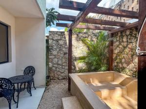 a bath tub in a patio with a table and chairs at Esencia Valladolid Hotel in Valladolid