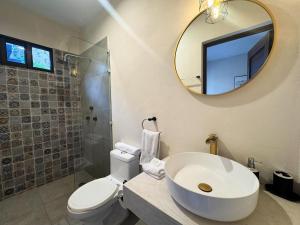 a bathroom with a toilet and a sink and a mirror at Esencia Valladolid Hotel in Valladolid