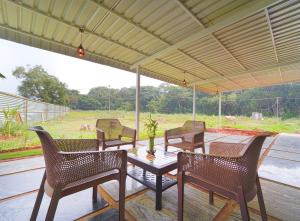a group of chairs and a table on a patio at Estoria Hotel and Resort in Mysore