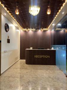 a reception desk in a room with a chandelier at Estoria Hotel and Resort in Mysore