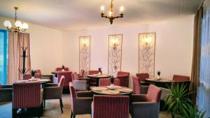 a restaurant with tables and chairs and a chandelier at Poiana Stelelor in Văleni