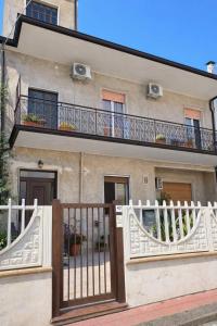 a house with a white fence and a balcony at CasaTreFontane in Bovalino Marina
