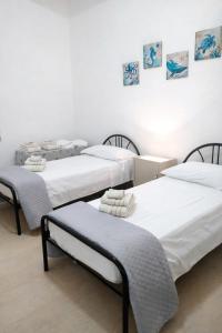 three beds in a room with white walls at CasaTreFontane in Bovalino Marina +4 photos