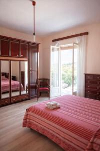 a bedroom with a large bed and a large window at CasaTreFontane in Bovalino Marina