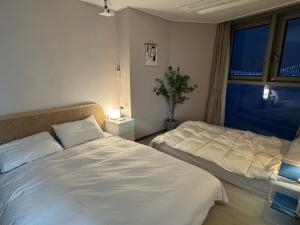 een slaapkamer met twee bedden en een raam bij Gwangan cozy in Kwangan-dong