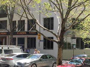 a parking lot with cars parked in front of a building at Europa Melbourne in Melbourne