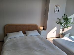 een slaapkamer met een bed en een potplant bij Gwangan cozy in Kwangan-dong +3 foto's