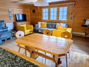 a living room with a table and a couch at Maisonette-Wohnung in Rueras bei Sedrun - 200m zum Bahnhof - Perfekt für Ski & Ausflüge in Rueras
