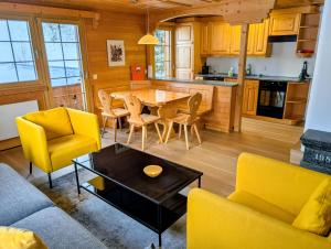 a kitchen and living room with a table and chairs at Maisonette-Wohnung in Rueras bei Sedrun - 200m zum Bahnhof - Perfekt für Ski & Ausflüge in Rueras