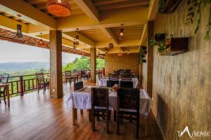 a restaurant with tables and chairs and a balcony at InSense Mountainview Resort in Siquijor