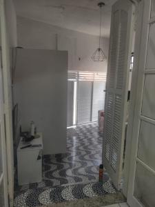a room with a hallway with a door and a kitchen at Espaço em Pero hospedagem in Cabo Frio