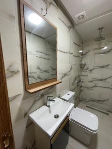 a bathroom with a sink and a toilet and a mirror at Hôtel kairouan in Fez