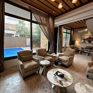a living room with chairs and tables and a pool at فلل بكمباوند خاص in Riyadh