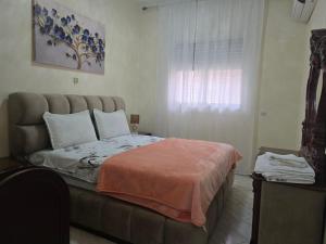 een slaapkamer met een bed met een groot hoofdeinde en een raam bij Appartement meublé in Meknès +5 foto's