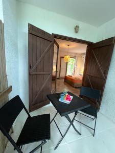 a room with a table and two chairs and a door at Thelazycoco in Blue Bay +1 photo