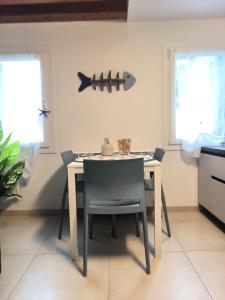 a dining room table and chairs in a kitchen at Chioggia Vibes - Appartamento centro storico e mare in Chioggia