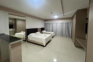 a hotel room with two beds and a television at Mega Palace Hotel in Morrinhos