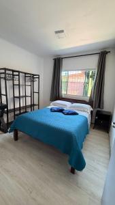 a bedroom with a large bed with a blue bedspread at Refúgio do Descanso in Florianópolis +36 photos