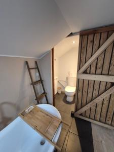 een badkamer met een houten deur en een toilet bij Chambre Cosy indépendante sans cuisine in Mont-Louis