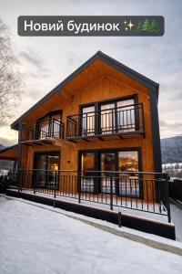 a house with a balcony on the side of it at Майя VIP in Mykulychyn