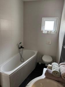 a bathroom with a tub and a toilet and a sink at Soba Lapaž in Toplice Sveti Martin