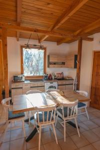 a kitchen with a wooden table and chairs at Élet Fája Vendégház in Kemence