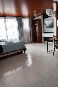 ein Schlafzimmer mit einem Bett und einem Fernseher in einem Zimmer in der Unterkunft Wiky House Guaduas in Guaduas