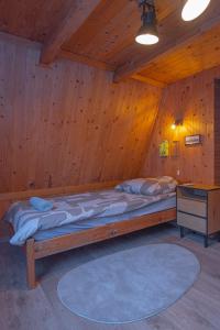 a bedroom with a large bed in a wooden room at Élet Fája Vendégház in Kemence