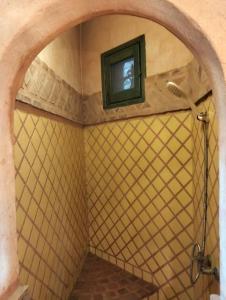 a bathroom with a shower with a tv on the wall at Chalet besides sakkara piramid in Cairo