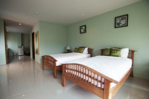 2 letti in una camera con pareti bianche di The Sun Terrace a Chiang Mai