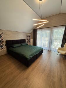 a bedroom with a bed in a room with wood floors at Майя VIP in Mykulychyn