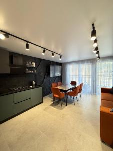 a kitchen and dining room with a table and chairs at Майя VIP in Mykulychyn