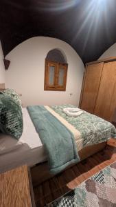 a bedroom with a bed with a green blanket on it at The Village House with Private Garden - Four Bedroom Nubian Home on Luxor West Bank in Luxor