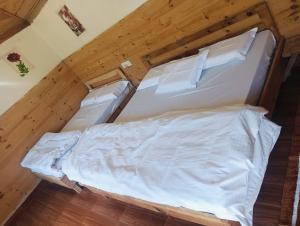 a large white bed in a room with wooden floors at Kinara Camping in Kailāna