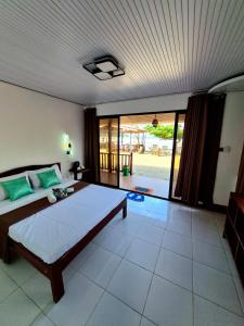 een slaapkamer met een groot bed en een groot raam bij Akoya Beach Park and Cottages in Locaroc