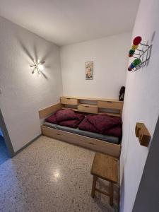 a small bedroom with a bed with red sheets at L'appart de Serre Che in La Salle Les Alpes +18 photos