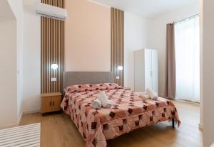a bedroom with a bed with a comforter on it at Il Giardinetto Guest House in Civitavecchia