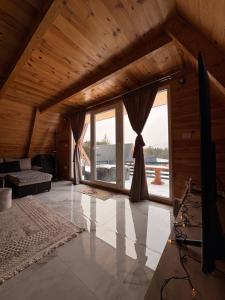 a living room with a large window and a couch at Vila Vrela in Žabljak
