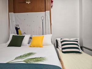 two beds with colorful pillows in a room at Bokman stay 01 in Seoul