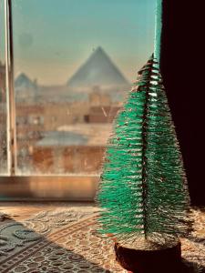 un albero di Natale verde appoggiato davanti a una finestra di Pyramidsfort & free pickup shuttle a Giza