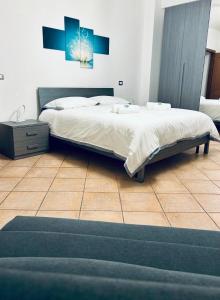 a bedroom with a large bed and a tiled floor at Urban Chic Apartment in Valmontone